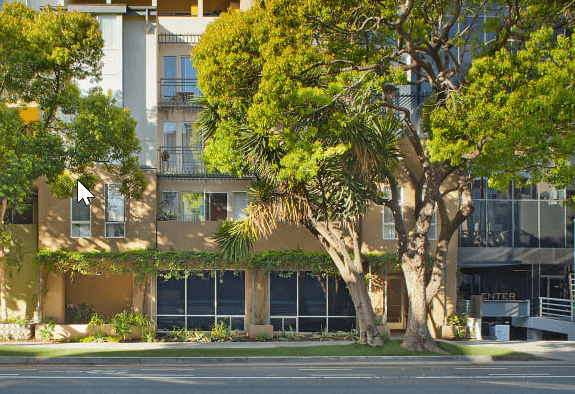 a building with trees in front of it on a street