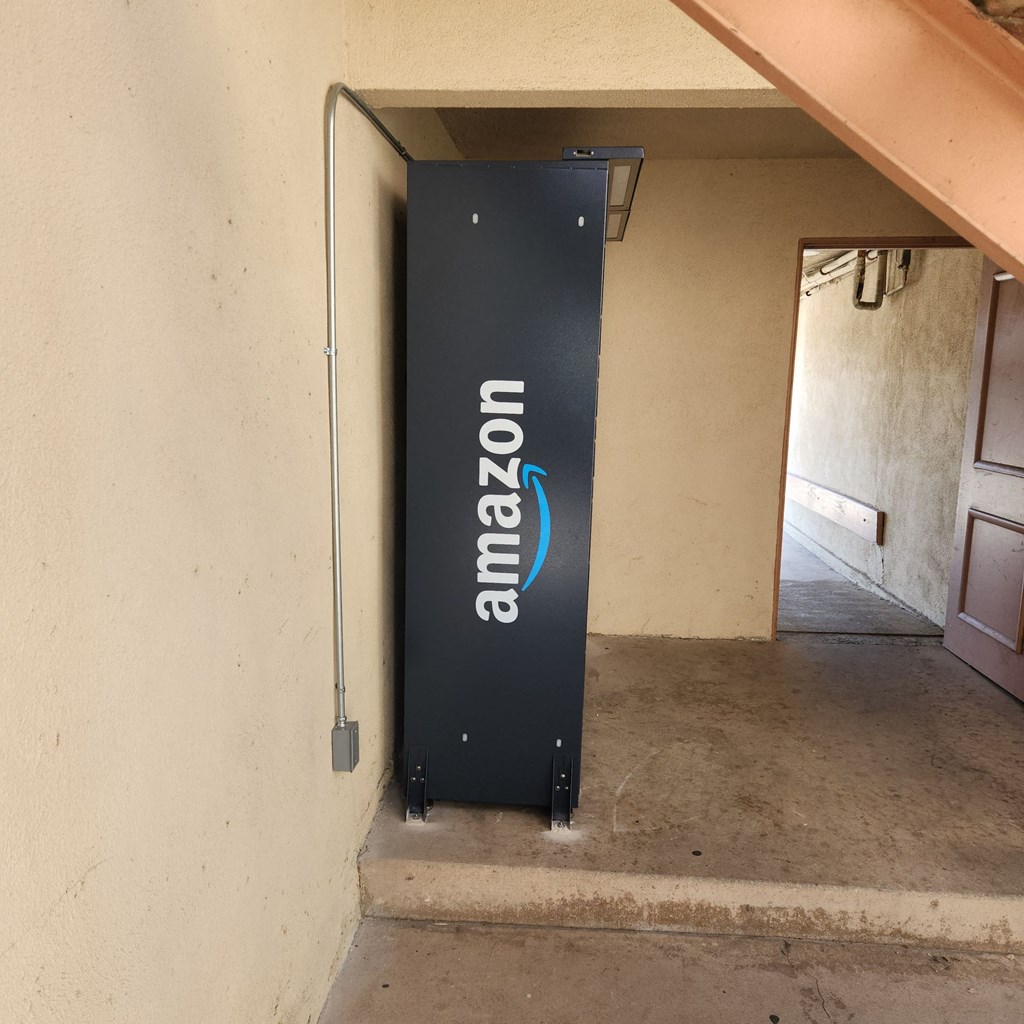 A tall black Amazon box sits in a corner.