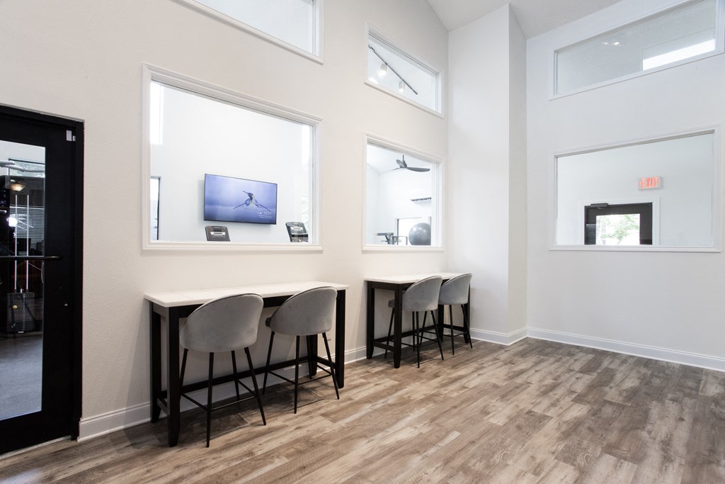 a dining room with three chairs and a table with three windows