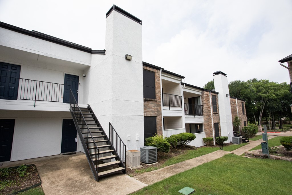 an exterior view of a building with stairs and a courtyard
