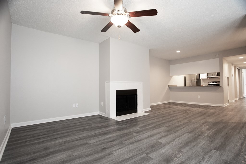 a living room with a fireplace and a ceiling fan