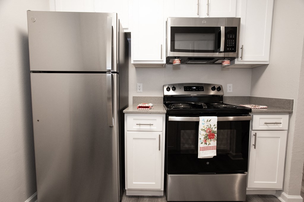 a kitchen with stainless steel appliances and white cabinets