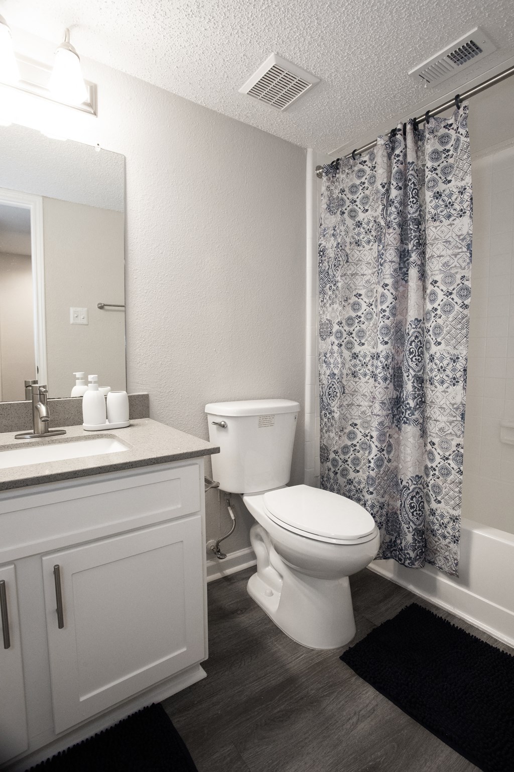 a bathroom with a shower and a toilet and a sink
