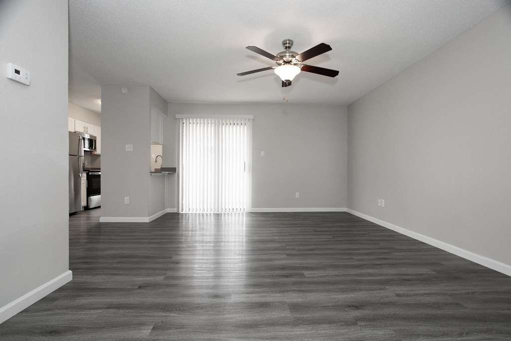 an empty living room with a ceiling fan