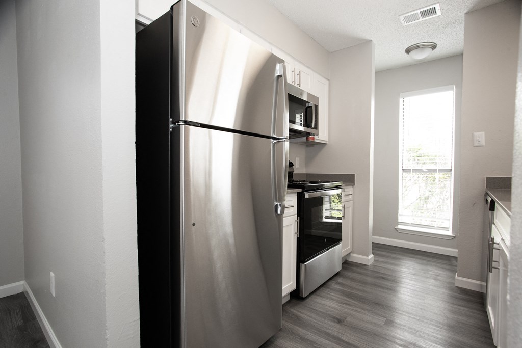 a stainless steel refrigerator and stove in a kitchen