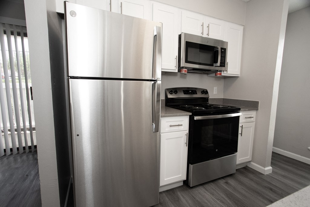 a kitchen with stainless steel appliances and white cabinets