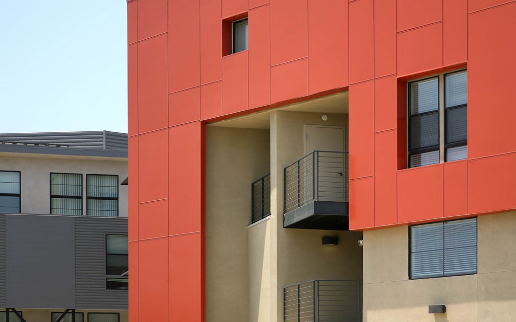 A red building with a balcony on the second floor.