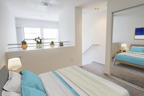 a bedroom with a bed and a mirror and a window