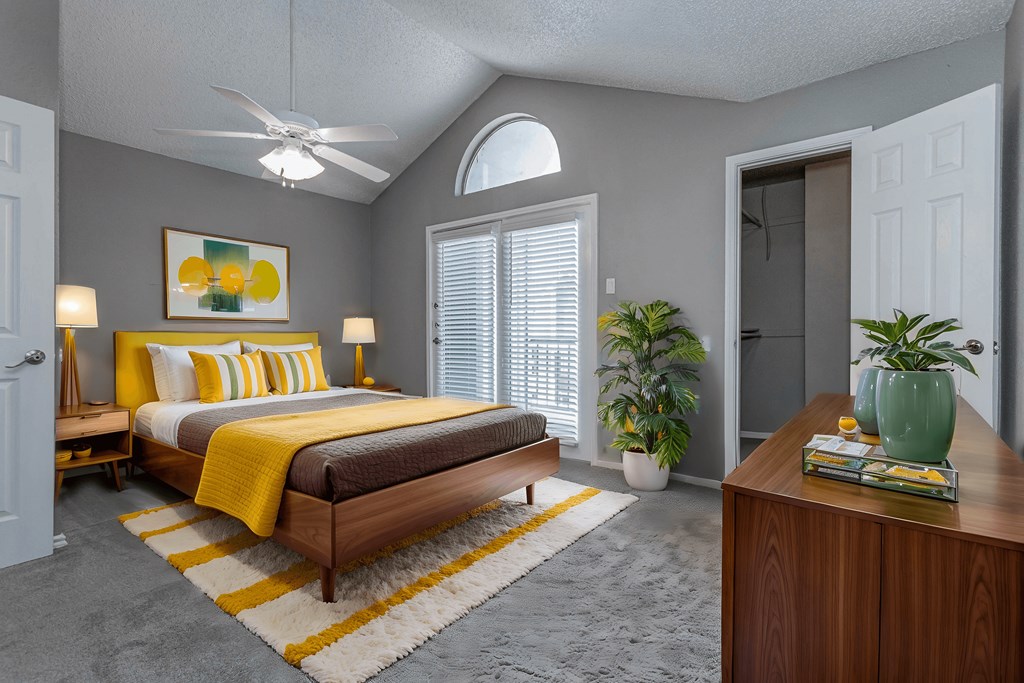 A bedroom with a bed, a ceiling fan, and a rug.