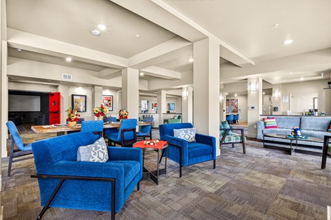 A living room with blue chairs and a grey couch.