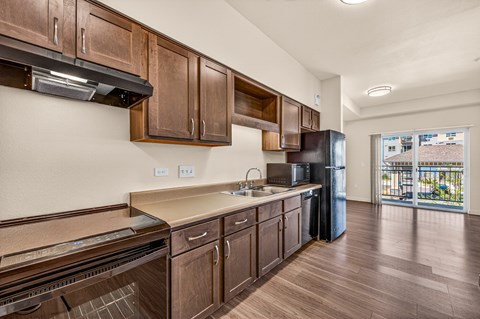 A kitchen with wooden cabinets and a black refrigerator.