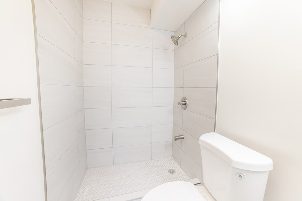 A white bathroom with a toilet, tub, and shower.