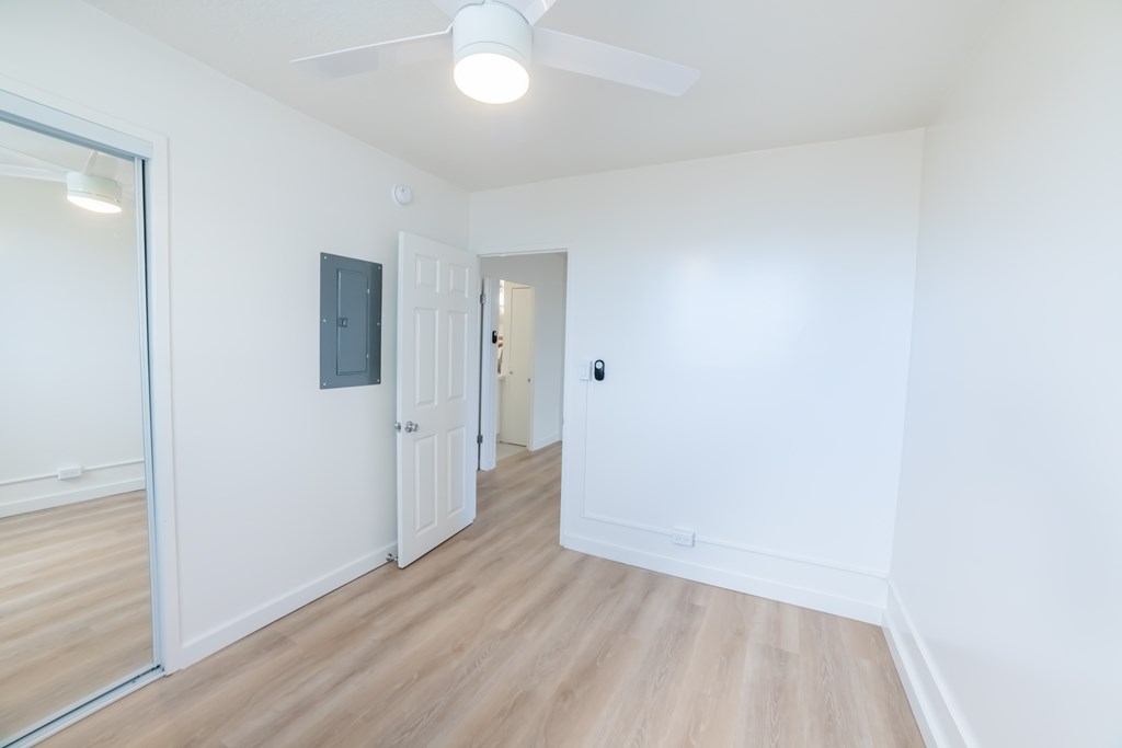 A room with a ceiling fan and a door.