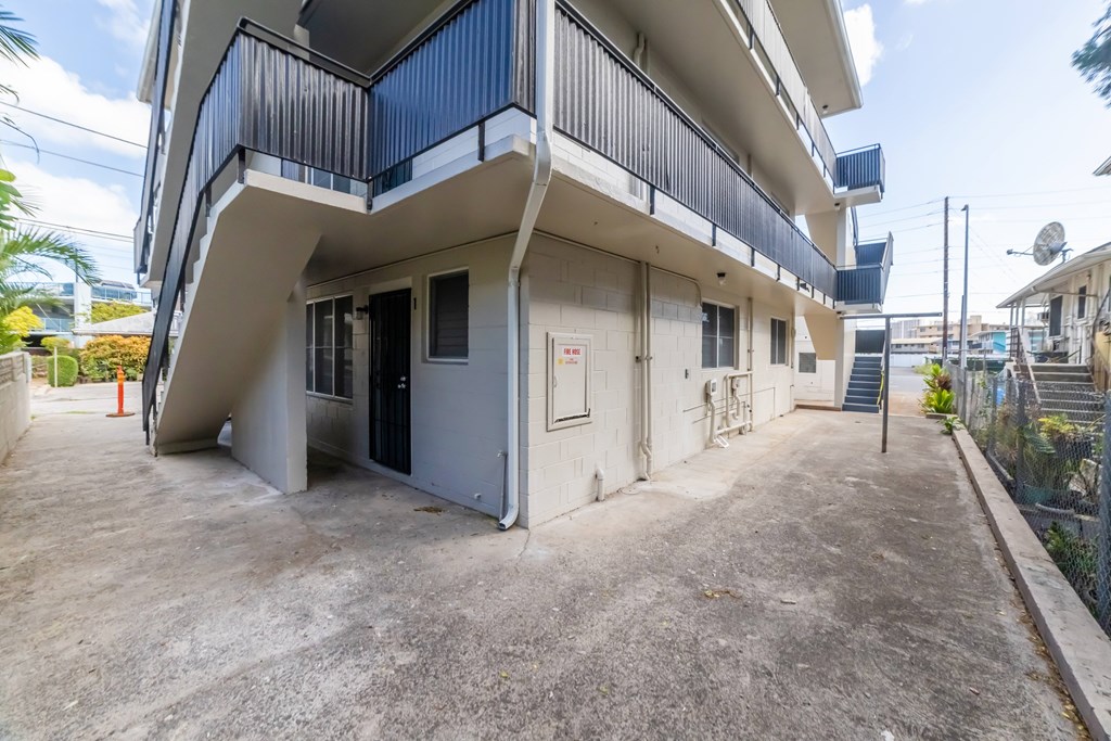 A white and blue building with a balcony and a door.