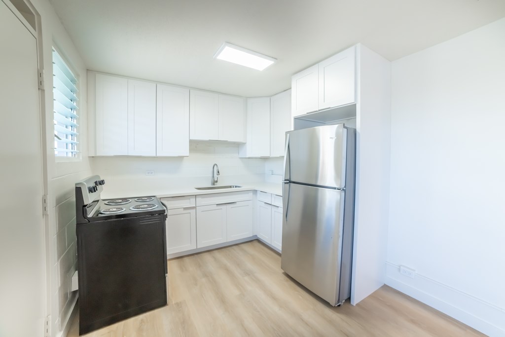 A kitchen with a black fridge and a black stove.