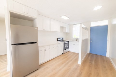 a renovated kitchen with white cabinets and stainless steel appliances