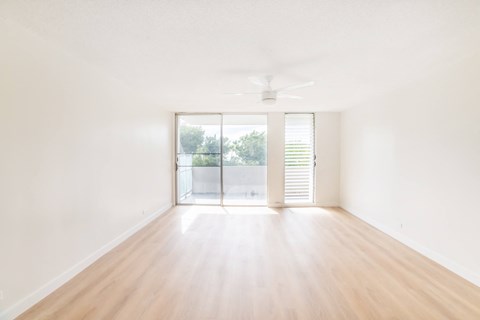 an empty living room with white walls and a sliding glass door