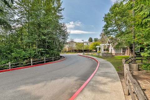 a curved road with a house and trees on the side of it