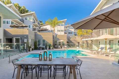 a table and chairs next to a swimming pool