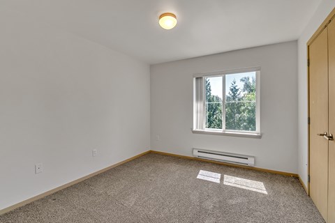 an empty room with a window and a door