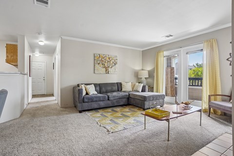 A living room with a grey couch and a yellow coffee table.