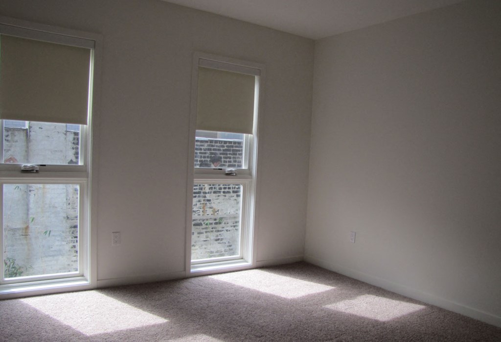 Mayfair Residences tall bedroom windows with shades closed