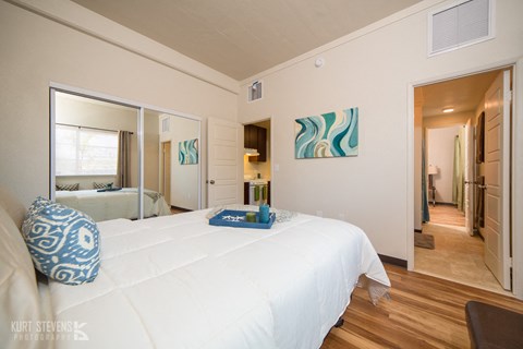 a bedroom with a large white bed and a mirror
