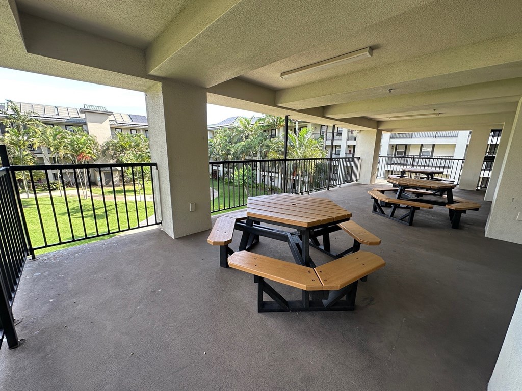 A patio with a black railing and a couple of benches.