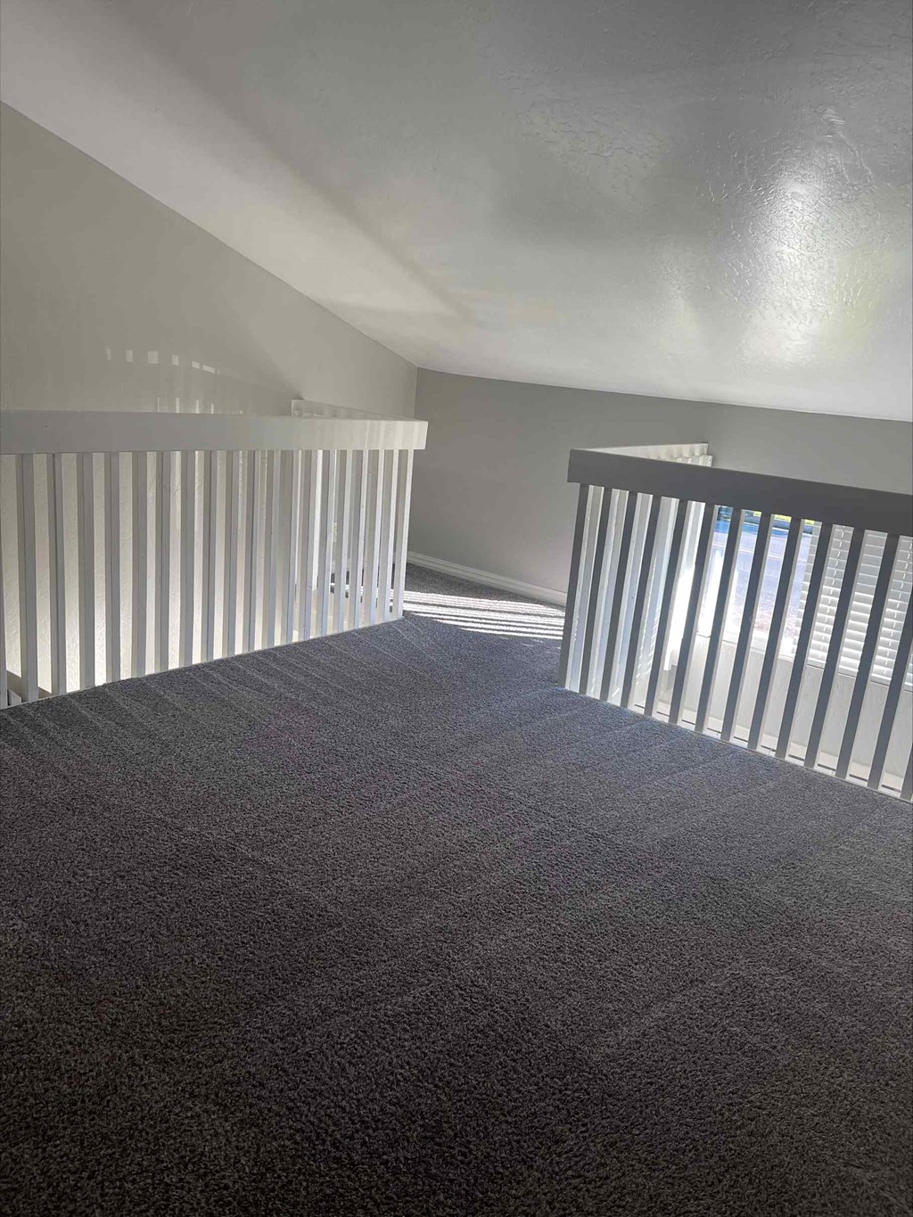 an empty room with a staircase and a railing