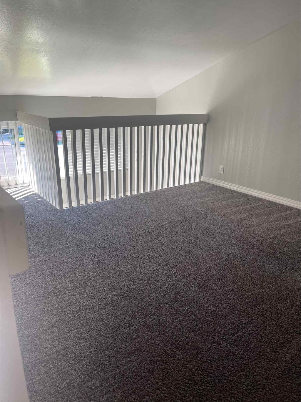 an empty room with gray carpet