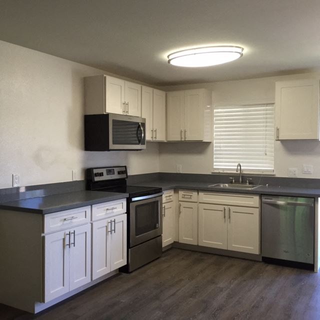 Front Street Apartments kitchen area with appliances, cabinets, and counters - Photo Gallery 1