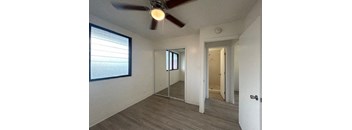 an empty room with a ceiling fan and a mirror