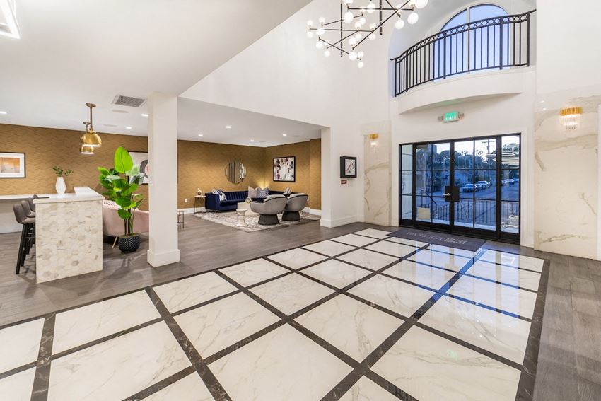 The Plaza at Sherman Oaks Luxury Apartments lobby with a reception desk and a door with a balcony - Photo Gallery