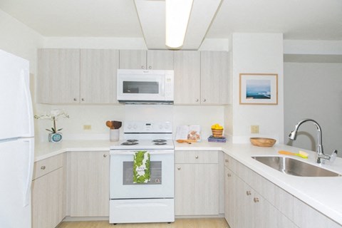 a white kitchen with white appliances and white cabinets