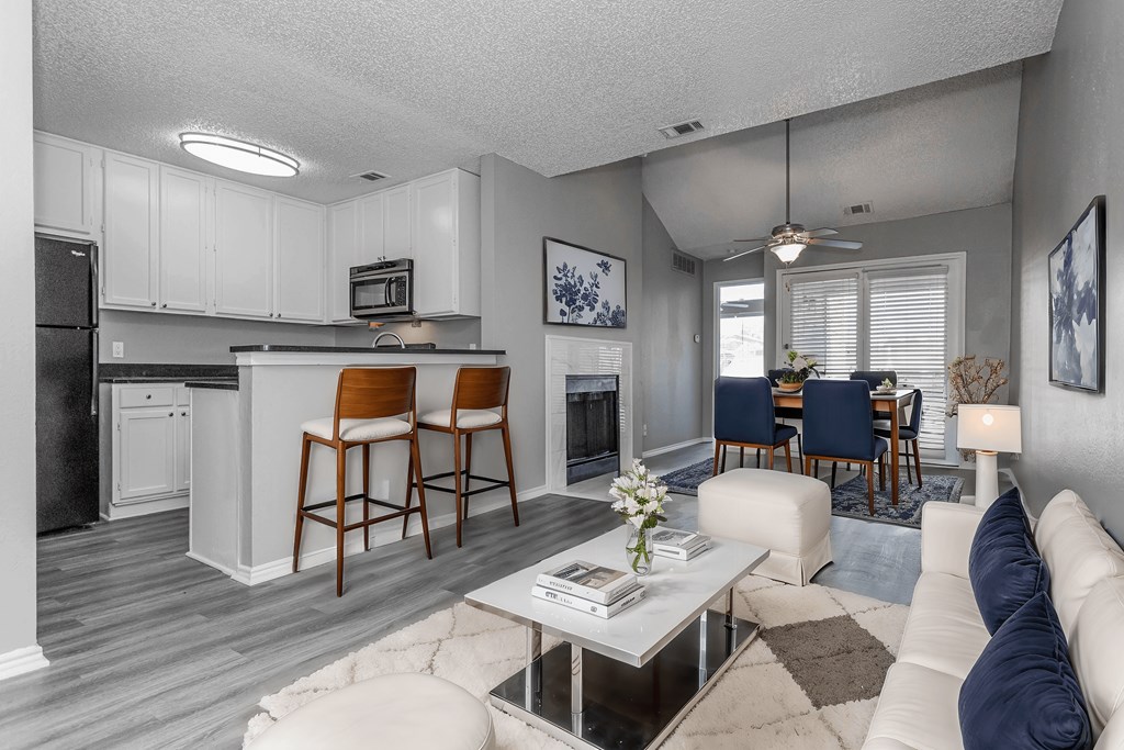 A modern kitchen with white cabinets and a bar area.
