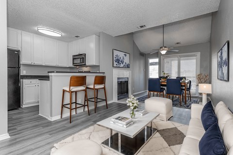 A modern kitchen with white cabinets and a bar area.