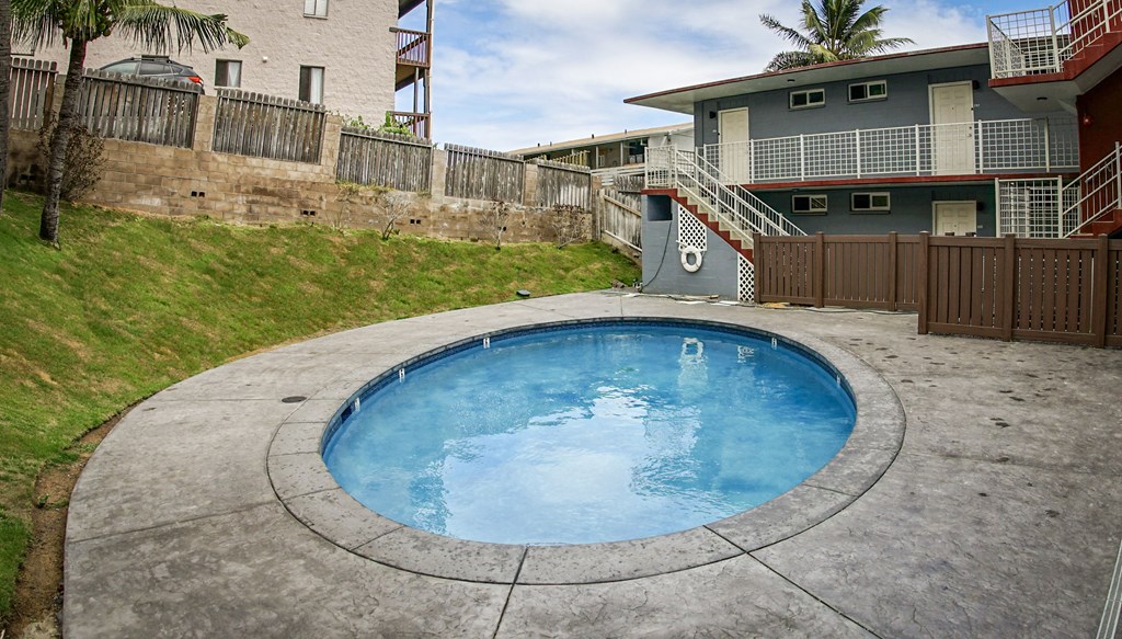 a backyard with a pool and patio with a house in the background