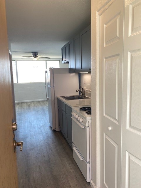 A kitchen with a white stove and a white refrigerator.