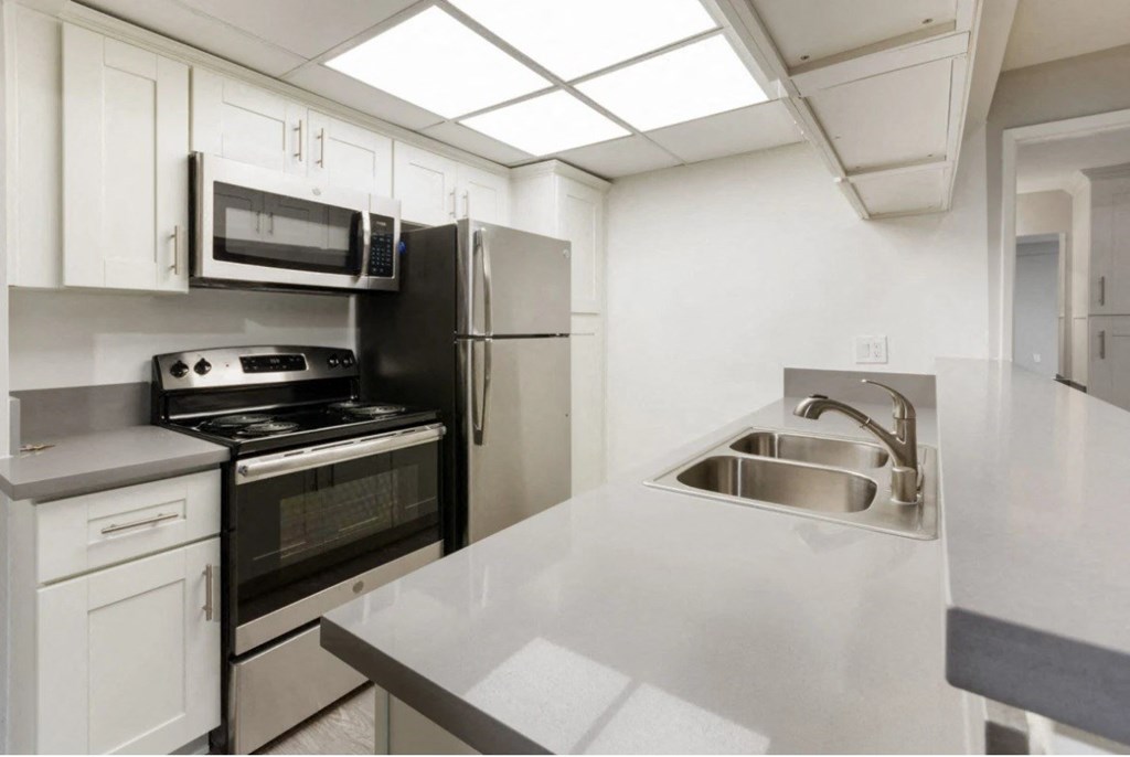 a kitchen with white cabinets and a sink and a refrigerator