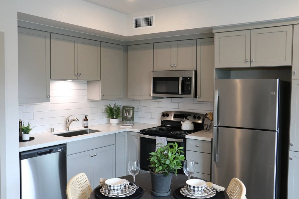 a kitchen with white cabinets and stainless steel appliances