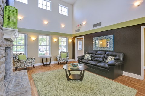 A living room with a black couch and a fireplace.
