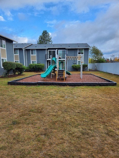 a yard with a playground and a house