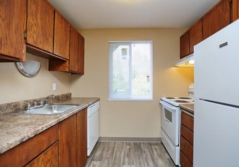 A kitchen with wooden cabinets and white appliances.