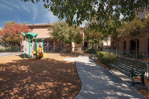 A playground with a slide and a bench.