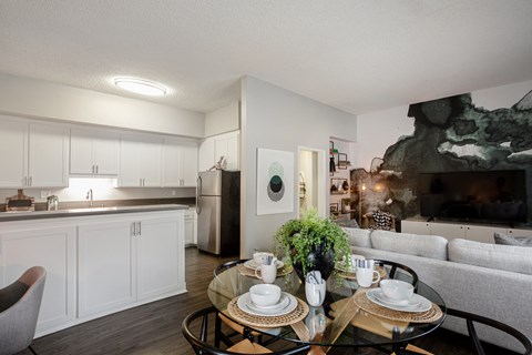 an open kitchen and living room with a glass table
