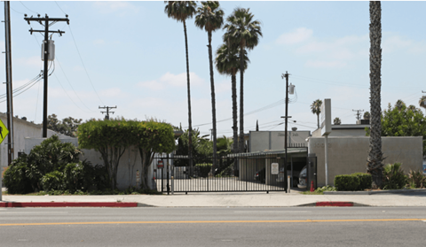 a house with a gate and palm trees