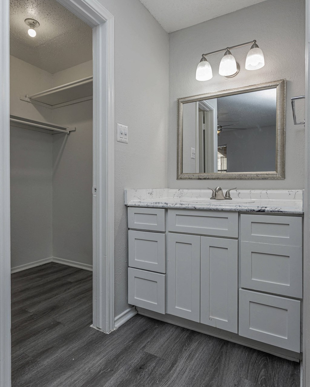 a bathroom with white cabinets and a sink and a mirror