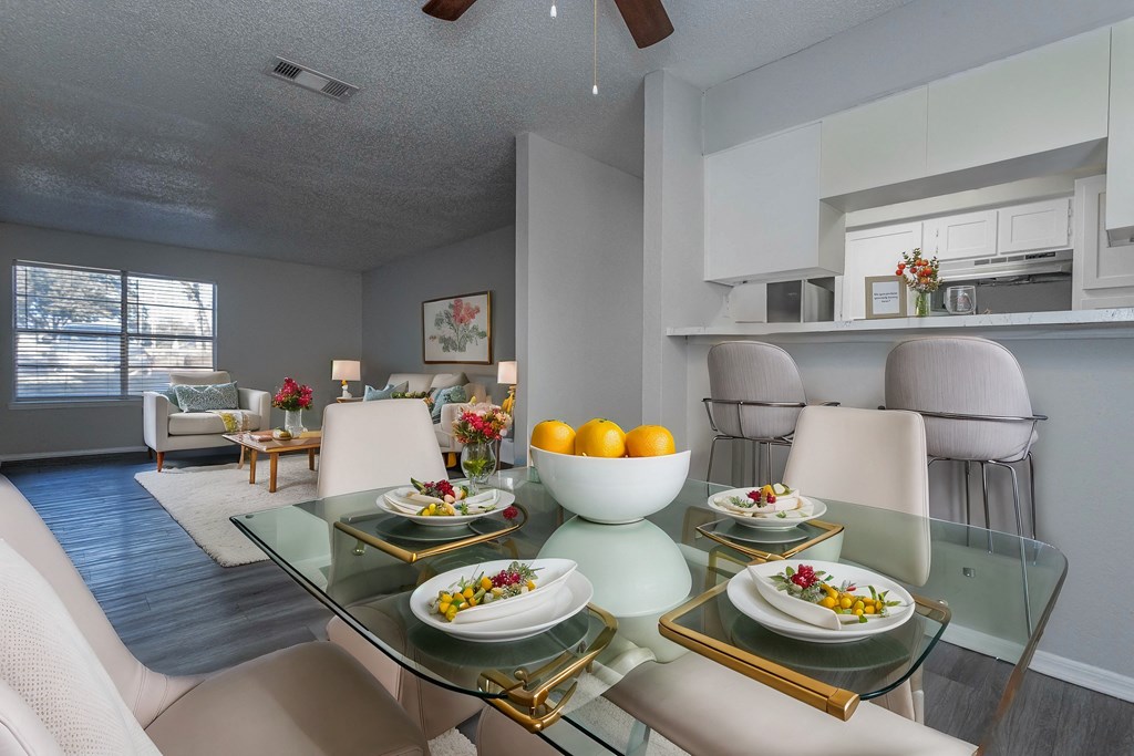 A dining room with a glass table and chairs.