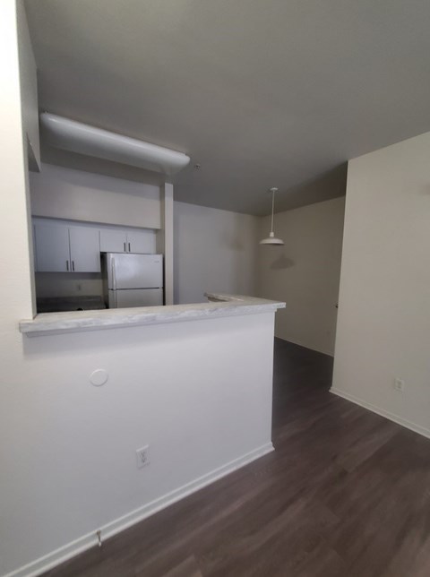 A kitchen area with white cabinets and a counter.