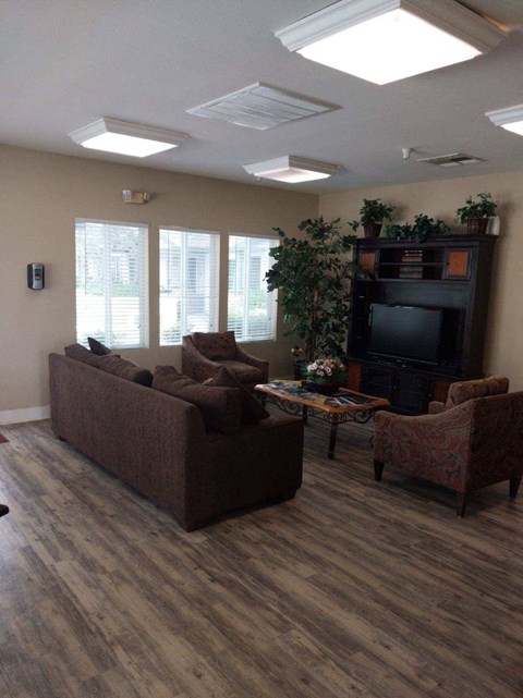 A living room with a couch, chairs, and a television.